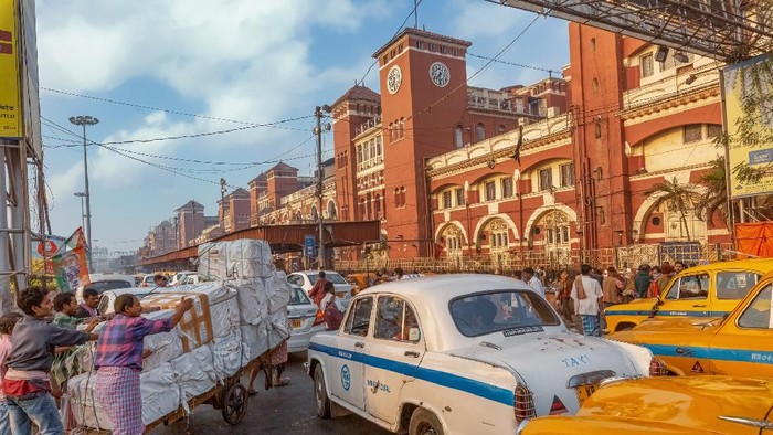 Kolkata, India, January 10, 2021: View of busy Howrah station with traffic jam and view of hand drawn cart with railway freight at Kolkata India