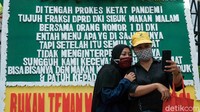Tampak warga berfoto dengan latar belakang karangan bunga. 