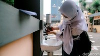 Para siswa diwajibkan untuk mencuci tangan sebelum memasuki area sekolah.