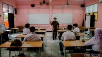 Seorang guru tengah menerangkan materi pelajaran kepada para siswa yang hadir mengikuti uji coba sekolah tatap muka di SMAN 1 Tangerang, Kota Tangerang, Senin (6/9/2021). 