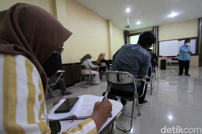 Mahasiswa fakultas Hukum Universitas Sebelas Maret mengikuti perkuliahan uji coba di ruang perkuliahan UNS, Solo, Jawa Tengah, Senin (9/6). Selain perkuliahan  yang berlangsung off line, pihak kampus juga menyelenggarakan perkuliahan secara daring. UNS merupakan salah satu universitas di Solo yang mendapatkan ijin untuk menyelenggarakan uji coba perkuliahan tatap muka pertama kali di Solo ditengah penerapan PPKM level 3.