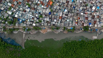 Rakesh Pulapa (India). Rumah-rumah di pinggir kota Kakinada mencapai muara, disangga dari laut oleh sisa-sisa rawa bakau. Alat: DJI Mavic 2 Pro; 1/80 second at f3.2; ISO200. Foto: Wildlife Photographer of the Year