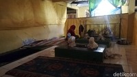 Seorang perempuan sedang berdoa di tiga makam keramat lainnya.