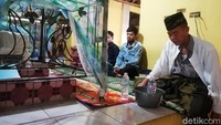Sang Juru Kunci sedang membacakan doa ritual bagi dua peziarah yang berkunjung ke Makam Keramat Marongge.