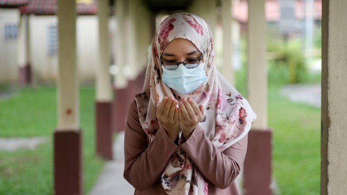 Ilustrasi wanita berhijab berdoa A female adult is putting both hands together for doa (Muslim way of praying) during partial lockdown in Malaysia.