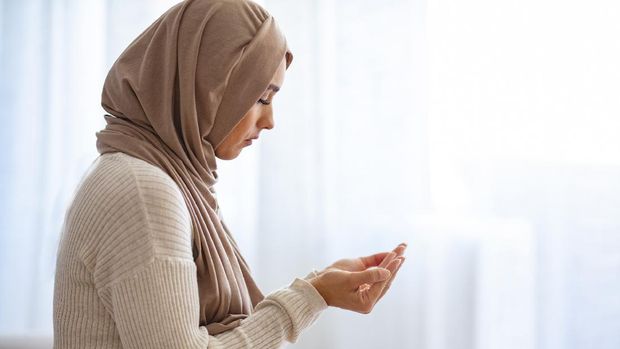 A female adult is putting both hands together for 'doa' (Muslim way of praying) during partial lockdown in Malaysia.