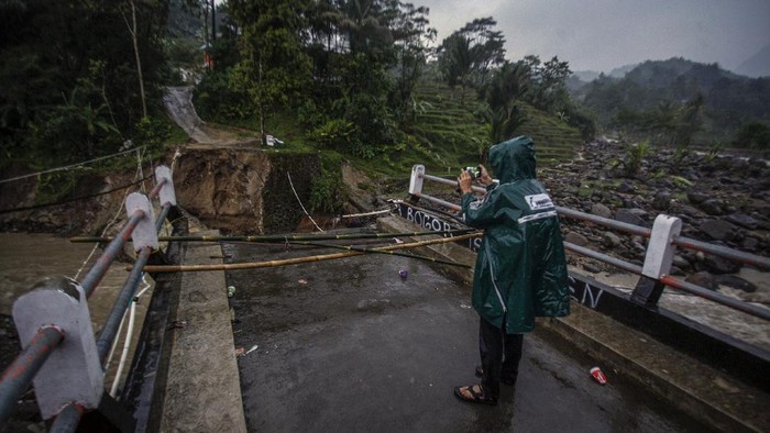 JEMBATAN TERPUTUS DITERJANG BANJIR BANDANG Warga melihat kondisi jembatan perbatasan Kecamatan Sukajaya dan Kecamatan Nanggung yang terputus di Desa Urug, Sukajaya, Kabupaten Bogor, Jawa Barat, Selasa (7/9/2021). Ambruknya jembatan yang disebabkan banjir bandang aliran Sungai Cidurian itu mengakibatkan akses jalan warga antar Kecamatan terputus. ANTARA FOTO/Yulius Satria Wijaya/rwa.