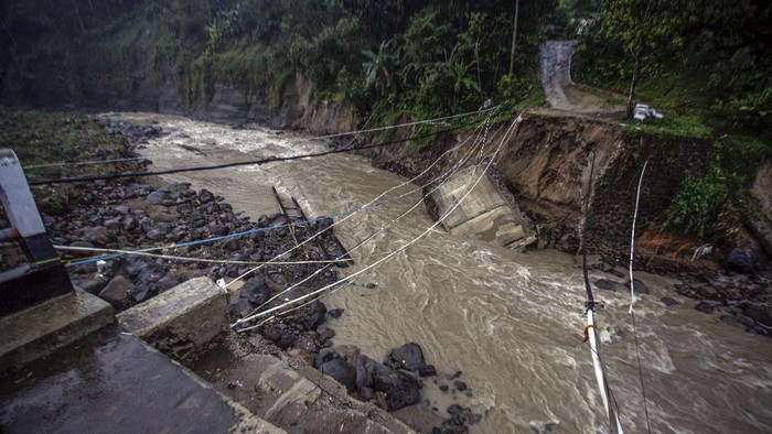 Warga melihat kondisi jembatan perbatasan Kecamatan Sukajaya dan Kecamatan Nanggung yang terputus di Desa Urug, Sukajaya, Kabupaten Bogor, Jawa Barat, Selasa (7/9/2021). Ambruknya jembatan yang disebabkan banjir bandang aliran Sungai Cidurian itu mengakibatkan akses jalan warga antar Kecamatan terputus. ANTARA FOTO/Yulius Satria Wijaya/rwa.