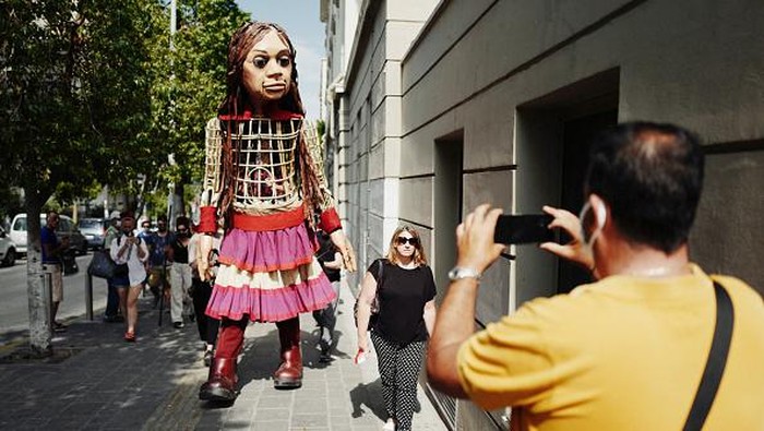 PIRAEUS, GREECE - SEPTEMBER 04: Artists perform alongside Little Amal, a giant puppet depicting a young Syrian refugee girl, outside the Municipal Theatre of Piraeus on September 4, 2021 in Piraeus, Greece. Little Amal is a 3.5 metre puppet walking 8,000 kilometres across Europe to highlight the plight of child refugees. There are some 26 million refugees worldwide, and more than half of them are children. (Photo by Ayman Oghanna/Getty Images)
