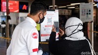 Petugas stasiun membantu calon penumpang mengenai penggunaan aplikasi ini.