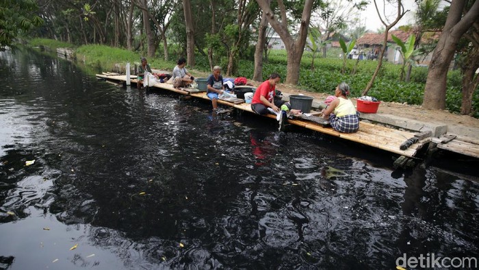 Warga mencuci dialiran saluran Kali Cilemahabang yang hitam pekat dan berbau akibat tercemar limbah pabrik di Kampung Sukamantri, Desa Sukaraya, Karang Bahagia, Kabupaten Bekasi, Jawa Barat, Selasa (7/9/2021). Meski tercemar limbah hitam pekat dan berbau warga bantaran Kali cilemahabang masih memanfaatkan air kali tersebut untuk memenuhi kebutuhan sehari-hari. Warga sekitar mengatakan, air sungai tersebut mulai menghitam sejak empat tahun lalu.