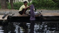 Meski tercemar limbah dan bau, warga bantaran Kali Cilemahabang masih memanfaatkan aliran air untuk mencuci pakaian.