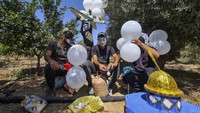 Kelompok militan Hamas yang berkuasa di Gaza meluncurkan lebih dari selusin balon api sebagai tanda perlawanan ke Israel.  