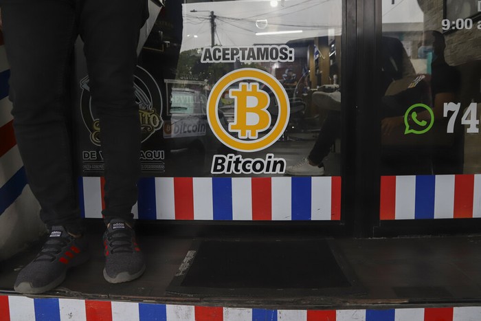 El Salvador Bitcoin A man holds a sign with a message that reads in Spanish;