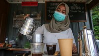 Seorang pelayan tengah membuat kopi.