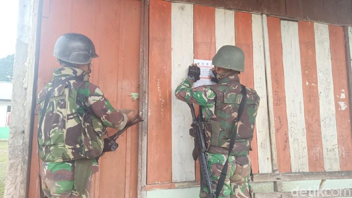 Sejumlah personel TNI berpatroli dan menempelkan selebaran ajakan kepada warga untuk kembali ke kampung. (dok Kodam Kasuari)