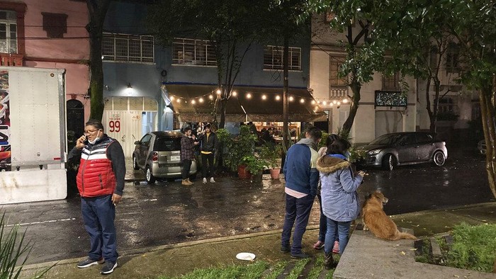 Diguncang Gempa, Warga Meksiko Tidur di Jalan People gather outside on the sidewalk after a strong earthquake was felt, in the Roma neighborhood of Mexico City, Tuesday, Sept. 7, 2021. The quake struck southern Mexico near the resort of Acapulco, causing buildings to rock and sway in Mexico City nearly 200 miles away. (AP Photo/Leslie Mazoch)