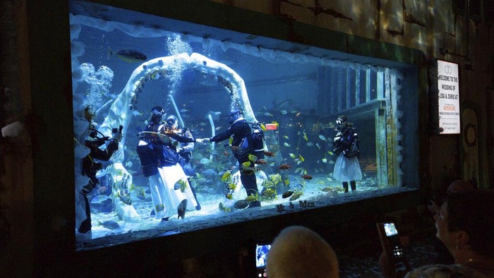 Serunya Menikah di Dalam Air Lisa Huggins and Chris Jackson exchange vowsa, during their underwater wedding ceremony, at Bear Grylls Adventure, in Birmingham, England, Wednesday, Sept. 8, 2021. The diving fans were due to marry abroad but had their plans scuppered during Covid, and had been looking for a unique alternative. (Jacob King/PA via AP)