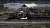 Lalu juga terlihat alat berat dengan roda bergerigi sedang menghancurkan batu bara dari tanah.   
