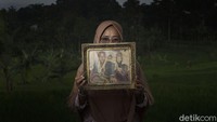 Siti Puadiah (42) memegangi foto pernikahannya, tak semua janda di kampung ini merupakan korban kecelakaan kerja tambang. Pupuh merupakan salah satu janda yang pisah dengan suami melalui putusan pengadilan beberapa tahun silam.