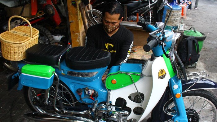 Montir Nanang Saiful Rohman memasang rangkaian pemutus daya atau Miniature Circuit Breaker (MCB) untuk jaringan listrik rumah tangga pada sepeda motor listrik hasil modifikasinya di bengkel Angsa Purba di Merjosari, Malang, Jawa Timur, Jumat (10/9/2021). Nanang memodifikasi sepeda motor klasik menjadi motor listrik dengan memanfaatkan peralatan listrik rumah tangga serta memasang baterai 60 volt 20 ampere sehingga mampu melaju dengan kecepatan sekitar 60 hingga 100 kilometer per jam. ANTARA FOTO/Ari Bowo Sucipto/wsj.