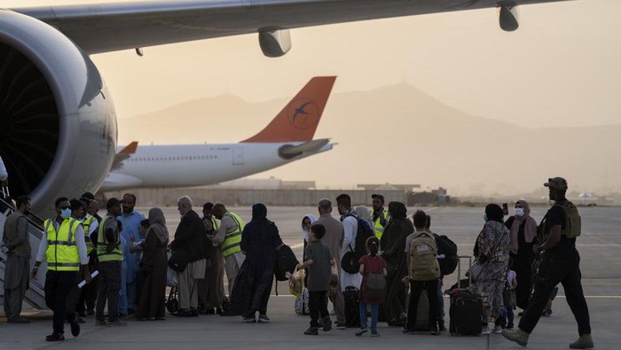 Foreigners board a Qatar Airways aircraft at the airport in Kabul, Afghanistan, Thursday, Sept. 9, 2021. Some 200 foreigners, including Americans, flew out of Afghanistan on an international commercial flight from Kabul airport on Thursday, the first such large-scale departure since U.S and foreign forces concluded their frantic withdrawal at the end of last month. (AP Photo/Bernat Armangue)