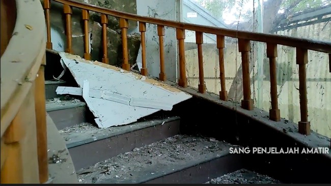 Puing-puing bekas tembok dan plafon mengotori tangga yang dulunya megah. (Foto: YouTube/Sang Penjelajah Amatir)