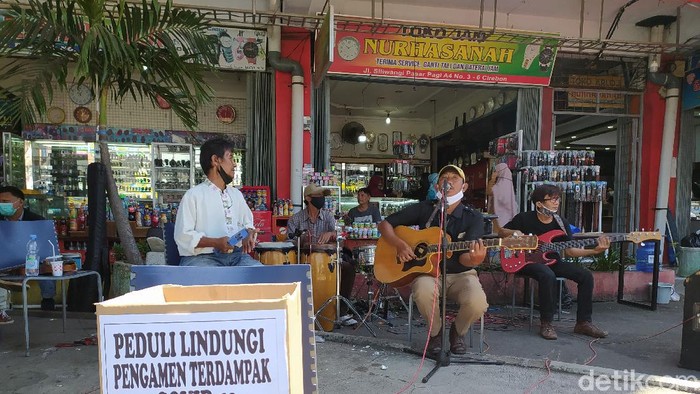 Satpol PP dan pengamen jalanan di Cirebon sosialisasi penerapan prokes ke warga.