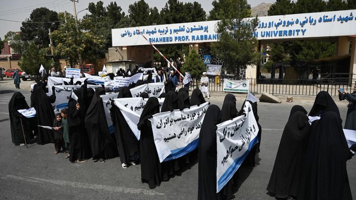 Veiled women hold banners and placards while marching during a pro-Taliban rally outside the Shaheed Rabbani Education University in Kabul on September 11, 2021. (Photo by Aamir QURESHI / AFP)