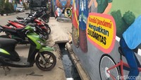 Anies terperosok tepat di ujung got yang berbatasan dengan jembatan ke sentra vaksinasi. Air got tampak berwarna hitam dan sejumlah campah ada di dalamnya. (Foto: Faiz/detikcom)