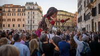 Potret boneka Little Amal saat dikeliling ratusan orang di tengah kota Roma, Italia.  Foto: Getty Images/Antonio Masiello