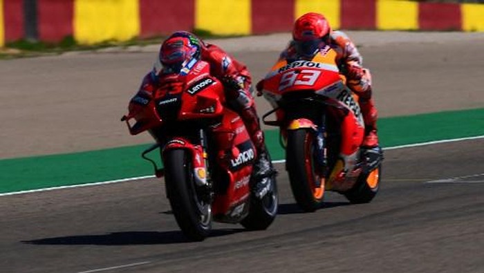 Ducati Italian rider Francesco Bagnaia crosses the finish line ahead of Honda Spanish rider Marc Marquez (R) during the Moto Grand Prix of Aragon at the Motorland circuit in Alcaniz on September 12, 2021. (Photo by LLUIS GENE / AFP)