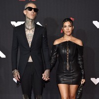 Kourtney Kardashian dan Travis Barker tampil kompak dengan busana bernuansa hitam. Kourtney mengenakan mini dress kulit dari desainer Olivier Theyskens. Dress bustier itu memiliki detail tali pada bagian depan sehingga membuat bagian tubuh Kourtney dari dada hingga perut tampak mengintip dari balik busananya. Foto: Evan Agostini/ Invision/AP/Evan Agostini