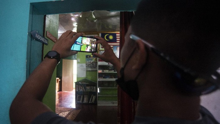 RUMAH TERLETAK DI DUA NEGARA Wisatawan berada di halaman rumah perbatasan patok 3 Indonesia-Malaysia di Pulau Sebatik, Nunukan, Kalimantan Utara, Senin (13/9/2021). Rumah tersebut terletak di dua negara, dimana ruang tamu di Indonesia sementara ruang baca dan dapur di Malaysia. ANTARA FOTO/Muhammad Adimaja/hp.