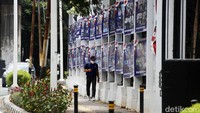 Warga melintas di samping pagar yang terpampang spanduk-spanduk HUT Partai Demokrat.