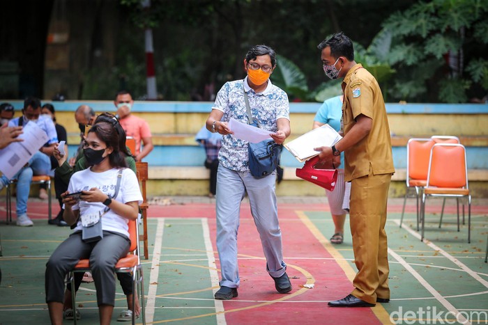 Sejumlah masyarakat mengantre untuk mendapatkan vaksinasi di RPTRA Gondangdia, Jakarta, Senin (13/9/2021). Hingga Minggu (12/9/2021) pukul 12.00 WIB, jumlah masyarakat yang sudah divaksinasi dosis kedua sebanyak 41.734.734 orang atau 20,04 persen dari total target sasaran vaksinasi.