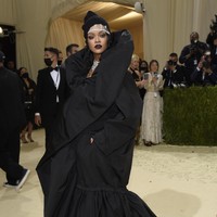 Bukan Rihanna namanya jika gayanya tak menghebohkan. Pilihannya kali ini jatuh pada gaun hitam bergaya piama oversized dengan kerah dramatis dari rumah mode Balenciaga. Aku seorang imigran. Itu caraku memaknai temanya, ujar pelantun Umbrella itu tentang inspirasi di balik gaun tersebut. (Foto: Invision/Evan Agostini/AP)