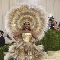 Supermodel Iman menebar pesonanya dengan jumpsuit emas dari Harris Reed dipadu rangka berstruktur ballgown sebagai luaran. Tidak ketinggalan sebuah headpiece bulu-bulu yang esktravaganza menyempurnakan gaya perempuan 66 tahun itu. (Foto: Invision/Evan Agostini/AP)