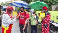Para badut tersebut berkeliling mengajak warga ke tempat dilaksanakannya kegiatan vaksinasi massal, di Mushala Al-Azhar.