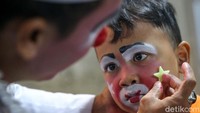 Seorang badut cilik tengah dihias sebelum beraksi.