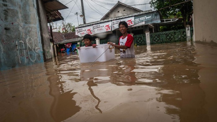 Orangtua mengevakuasi anaknya saat banjir di Rangkasbitung, Lebak, Banten, Selasa (14/9/2021). Tingginya intensitas hujan yang terjadi sejak Senin (13/9/2021) malam, menyebabkan ratusan rumah di Rangkasbitung terendam banjir setinggi dua meter. ANTARA FOTO/Muhammad Bagus Khoirunas/aww.