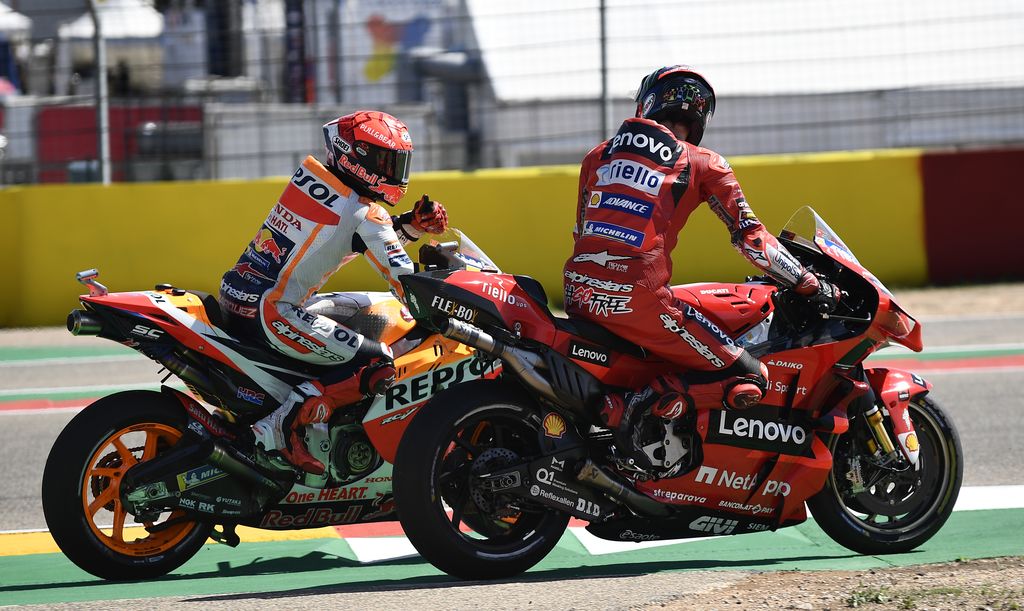 Marc Marquez of Spain, left, on his Honda gives a thumbs up to the winner of the race Francesco Bagnaia of Italy on his Ducati at the end of the Alcaniz Aragon Moto GP race at the MotorLand Aragon circuit, in Alcaniz, Spain Sunday, Sept. 12, 2021. (AP Photo/Jose Breton)