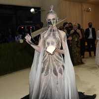 Penyanyi yang juga kekasih Elon Musk, Grimes, tampil menghebohkan di acara yang digelar di Metropolitan Museum of Art, New York City, AS, Senin (13/9/2021). Gaun karya Iris Van Harpen menjadi andalan Grimes. Ia memakai terusan putih keabu-abuan menerawang yang dihiasi motif zig-zag dan masker metalik senada.  Foto: Evan Agostini/Invision/AP