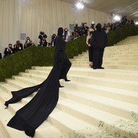 Kehadiran Kim Kardashian di Met Gala 2021 bersama seorang pria yang juga berbaju hitam hingga seluruh wajahnya tertutup sempat membuatnya dikira rujuk dengan Kanye West. Namun sosok pria tersebut bukanlah Kanye, melainkan creative director Balenciaga Demna Gvasalia. Foto: Evan Agostini/Invision/AP
