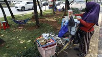 Nani (42) tengah menyiapkan minuman untuk seorang pembeli di depan Gedung DPR RI, Jalan Gatot Subroto, Jakarta, Selasa (14/9/2021).