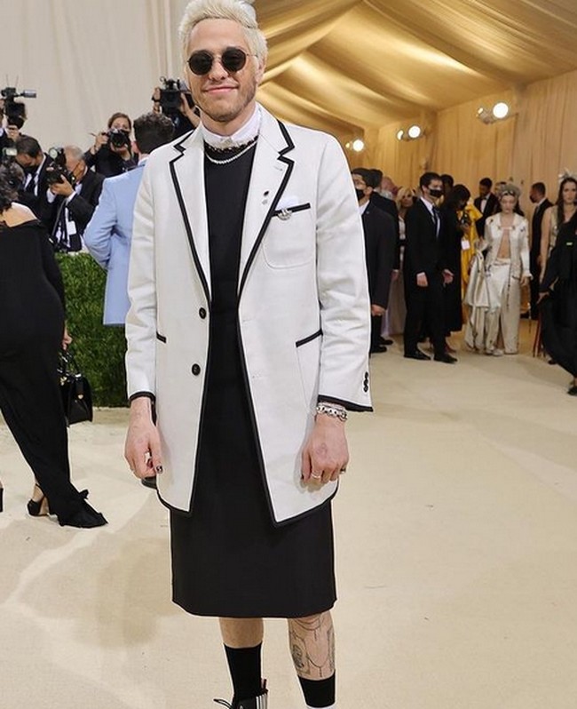 Dia menggunakan shift dress hitam dengan kerah putih. Tampak ada kalung berlian yang menghias lehernya. Dress hitamnya tersebut dipadukan dengan blazer putih. Jika kamu akan mengenakan dress, cara atau tempat apa yang lebih baik untuk melakukannya selain di Met Gala. Aku sangat senang dan bersemangat bahwa mereka mengira aku bisa melakukan ini. Ini sangat lucu, ungkap Pete Davidson. Foto: dok. Instagram/@metgala2021_official