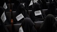Para sisiwi yang mengenakan niqab melambaikan bendera Taliban. Mereka mendukung penuh syariat islam di Afghanistan. 