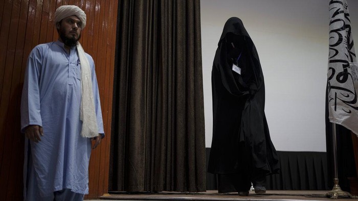 Berbalut Niqab, Siswi Afghanistan Dukung Penuh Taliban A women walks down from the stage inside an auditorium at Kabul University's education center during a demonstration in support of the Taliban government in Kabul, Afghanistan, Saturday, Sept. 11, 2021. (AP Photo/Felipe Dana)