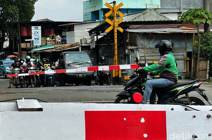 Seorang driver ojek online (ojol) nekat terobos palang pintu Kereta Api (KA) yang sudah tertutup di perlintasan, Jalan Pangadegan Selatan, Jakarta, Rabu (15/09/2021).