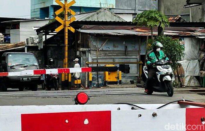 Seorang driver ojek online (ojol) nekat terobos palang pintu Kereta Api (KA) yang sudah tertutup di perlintasan, Jalan Pangadegan Selatan, Jakarta, Rabu (15/09/2021).